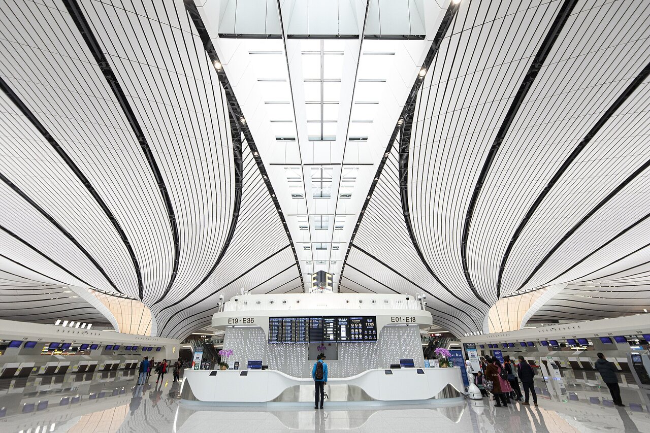 흰 곡면 천장이 흘러내리는 베이징 다싱 국제공항 출국장